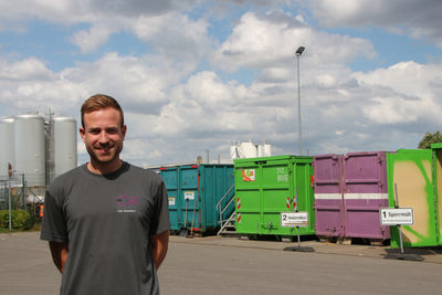Junger Mann vor Container